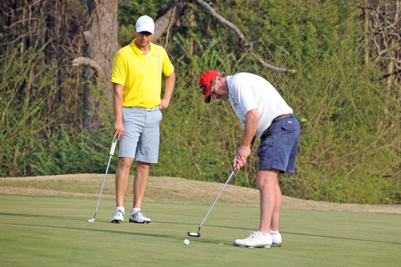 Two golfers on putting green